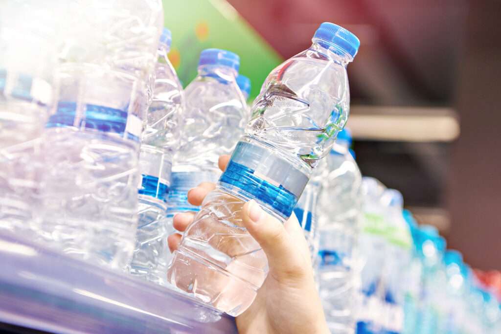 Water plastic bottle in hand at store